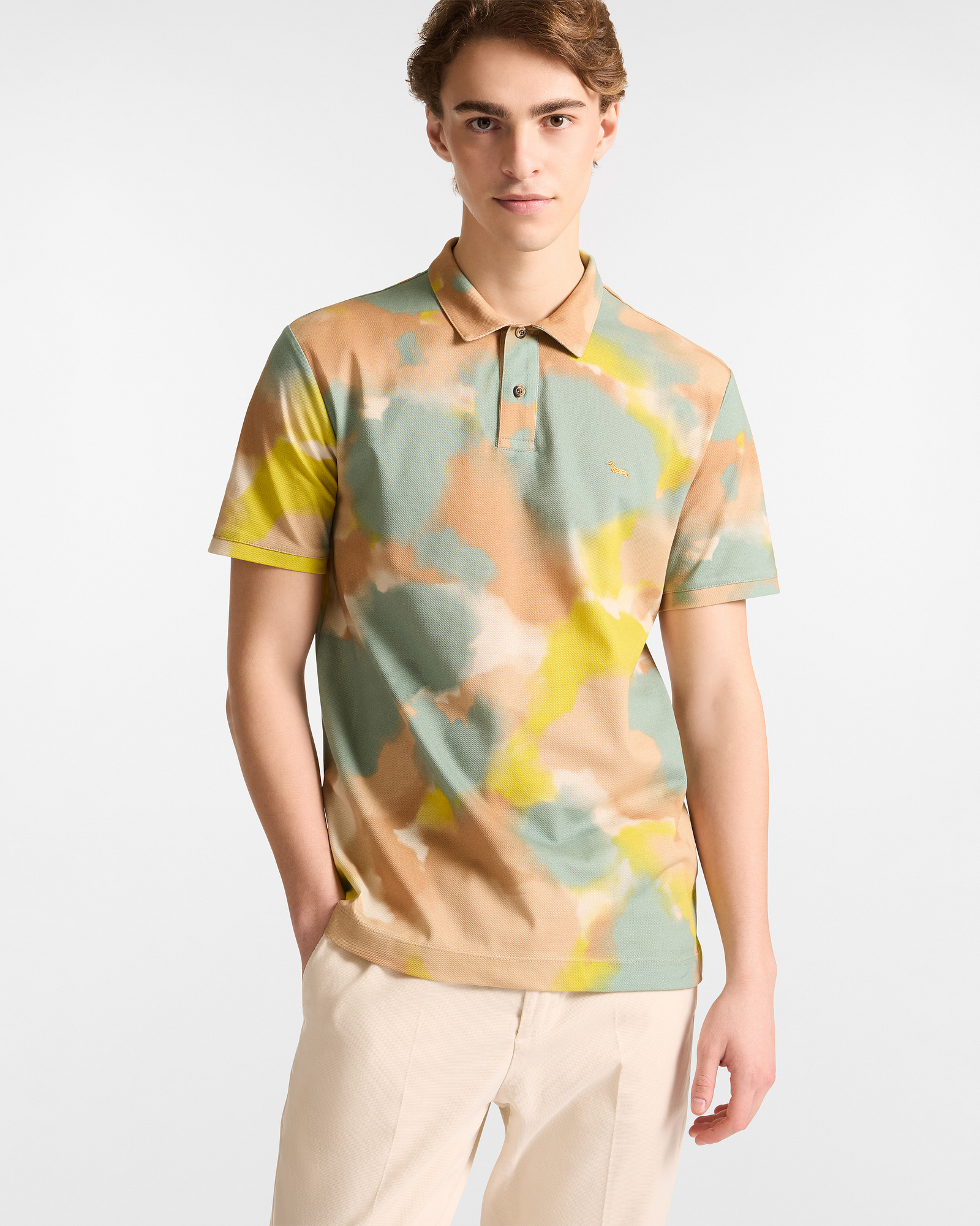Man in watercolor-effect printed polo shirt in green, beige and yellow tones